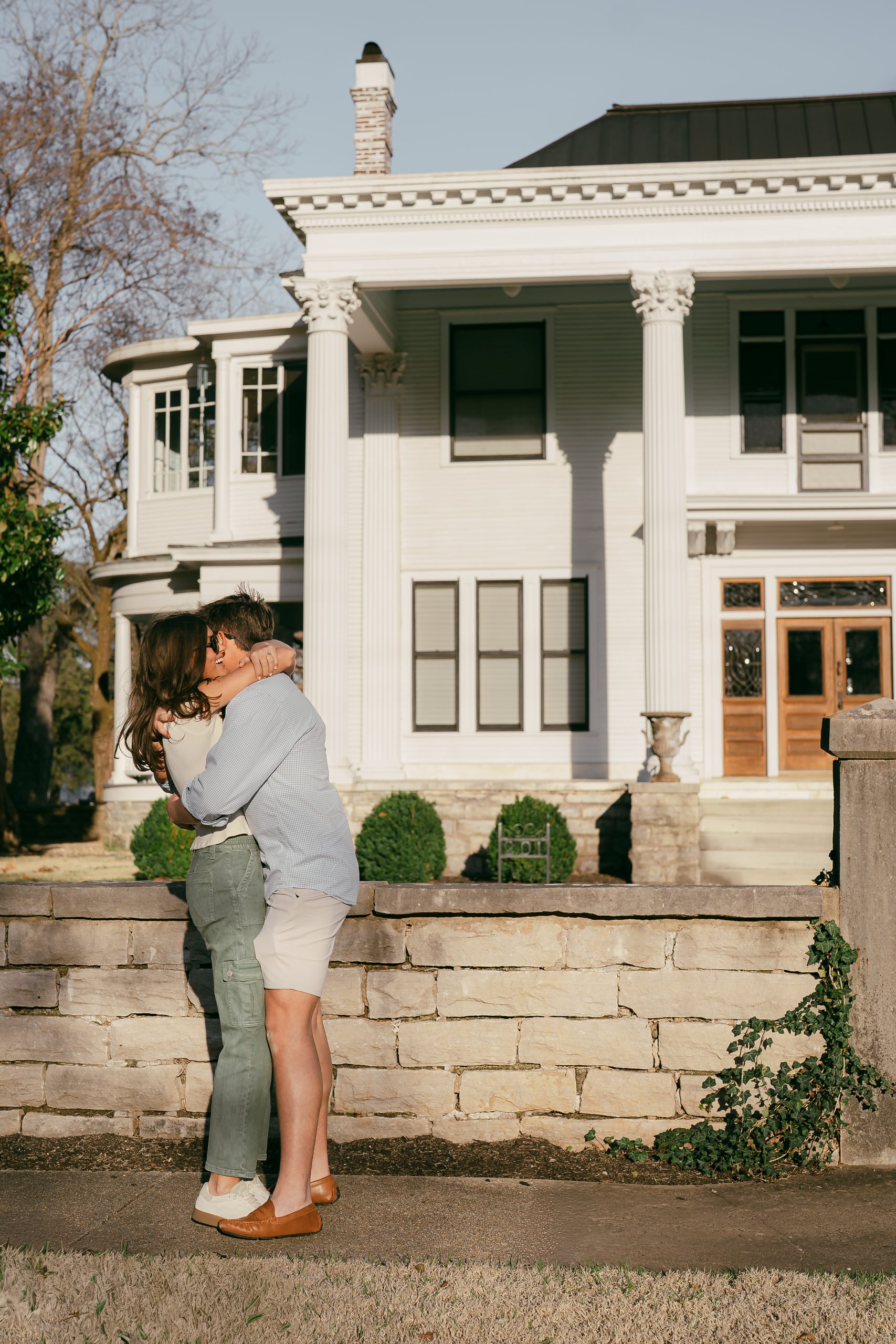A man gets down on one knee outside an elegant historic building, capturing a guy proposing to girl in Downtown Athens.